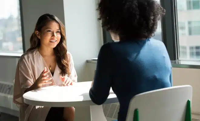 two women sitting on chair